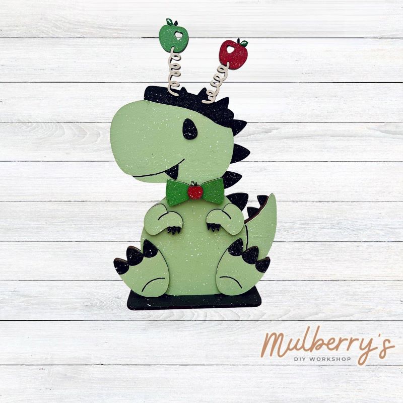 Our t-rex dinosaur is super cute! It's approximately 8" tall and can be paired with your favorite seasonal/holiday insert.
This set includes the interchangeable t-rex dinosaur and your choice of apple inserts:
-Headband with Bow Tie
-Apple
Please note that different inserts fit each type of dinosaur base differently.
