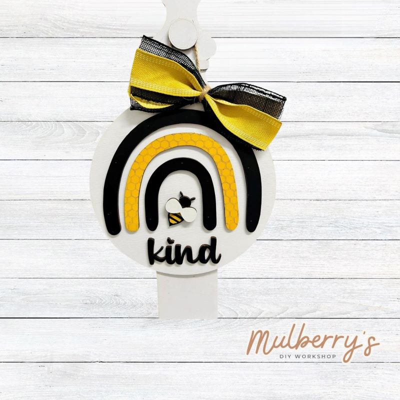 Our bee kind rainbow mini door hanger is too cute! Approximately 10" in diameter.