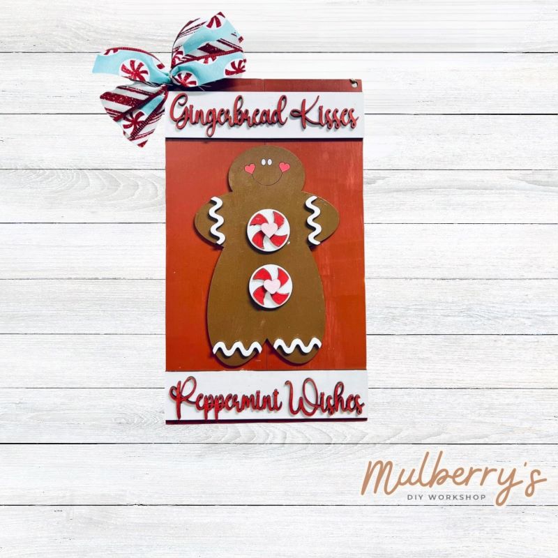 Our Gingerbread Kisses mini door hanger is too cute! Approximately 14" tall by 8" wide.