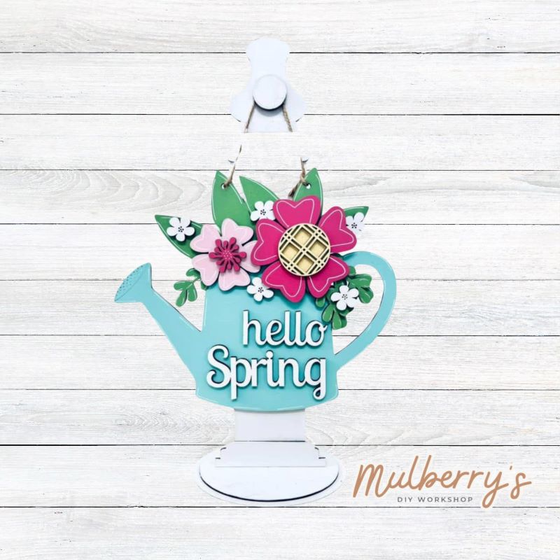 Our cheerful "Hello Spring" mini door hanger is a perfect addition for spring. It's approximately 12" tall by 10.5" wide with multiple layers of flowers.