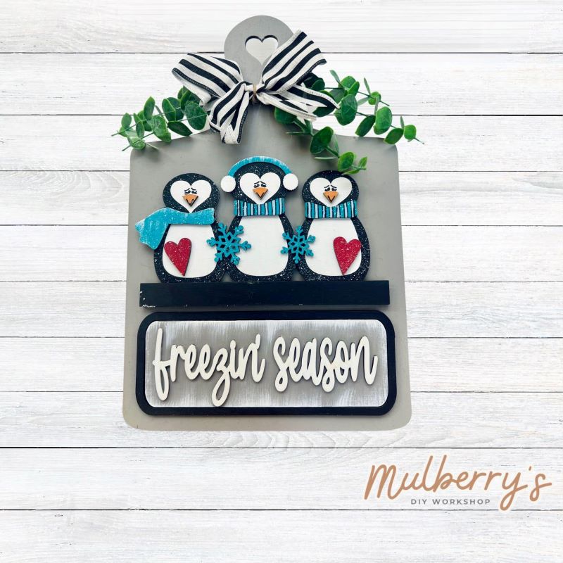 This Interchangeable Breadboard measures roughly 9" wide & 13.5" tall.
This project can easily be changed out for holidays, seasons and other themes. Because the breadboard leans back with the use of an easel, no magnets or adhesive hook and loop is needed.
The set includes the breadboard and winter penguin inserts.