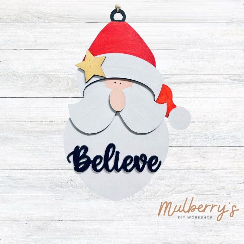 Our Believe Santa mini door hanger is so cute! Approximately 16" tall by 6" wide.