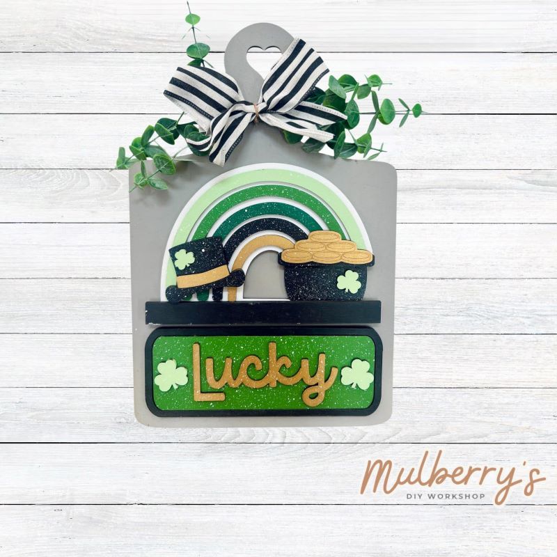 This Interchangeable Breadboard measures roughly 9" wide & 13.5" tall.
This project can easily be changed out for holidays, seasons and other themes. Because the breadboard leans back with the use of an easel, no magnets or adhesive hook and loop is needed.
The set includes the breadboard and st. patty rainbow inserts.