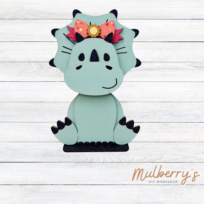Our triceratops dinosaur is super cute! It's approximately 11.5" tall and can be paired with your favorite seasonal/holiday insert.
This set includes the interchangeable triceratops dinosaur and your choice of summer inserts:
-Headband with Bow Tie
-Headbow
-Tropical Flower Lei
Please note that different inserts fit each type of dinosaur base differently. For our interchangeable triceratops, we recommended pairing it with the tropical flower lei insert.