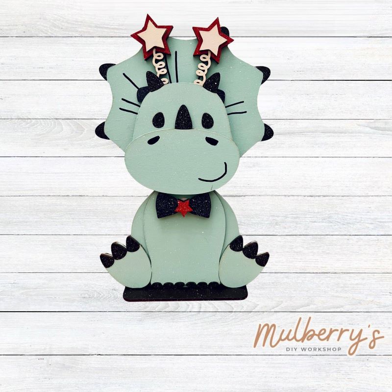 Our triceratops dinosaur is super cute! It's approximately 11.5" tall and can be paired with your favorite seasonal/holiday insert.
This set includes the interchangeable triceratops dinosaur and your choice of July 4th inserts:
-Headband with Bow Tie
-Headbow
-Statue of Liberty Spike Hat
Please note that different inserts fit each type of dinosaur base differently. For our interchangeable triceratops, we recommended pairing it with the statue of liberty spike hat insert.