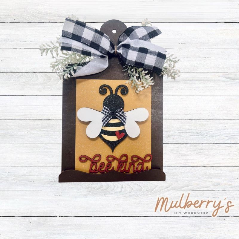 Our Interchangeable Mini Breadboard measures roughly 6.5" wide & 10.5" tall.

This project can easily be changed out for holidays, seasons and other themes. Because the breadboard leans back with the use of an easel, no magnets or adhesive hook and loop is needed.

The set includes the mini breadboard and bee kind insert.