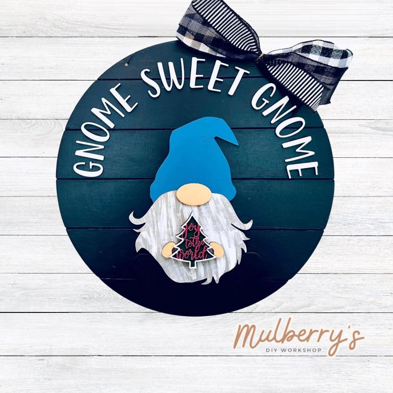 This sweet little fella will make you smile each season and holiday. Simply swap out his hands to create a brand new door hanger! The door hanger is approximately 18-inches in diameter and comes with or without greenery on the backer. Includes Gnome Sweet Gnome door hanger with Christmas insert.