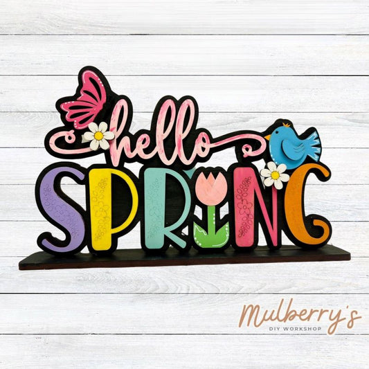 Our Hello Spring shelf sitter is the perfect addition to your spring decor! Approximately 9" wide by 6" tall. Includes stand.