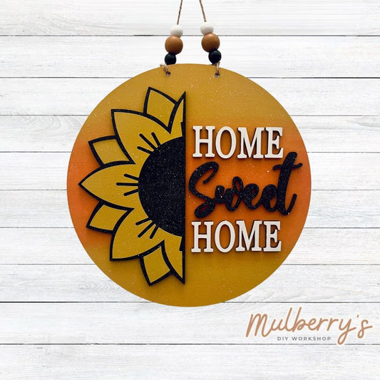 Embellish your home with our super cute "Home Sweet Home" sunflower mini door hanger! It's approximately 10.5" in diameter and includes your choice of either beads or a bow!
