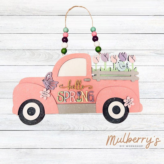 Our hello spring farmhouse truck mini door hanger is too cute! Approximately 7" tall by 12" wide. Includes your choice of beads.