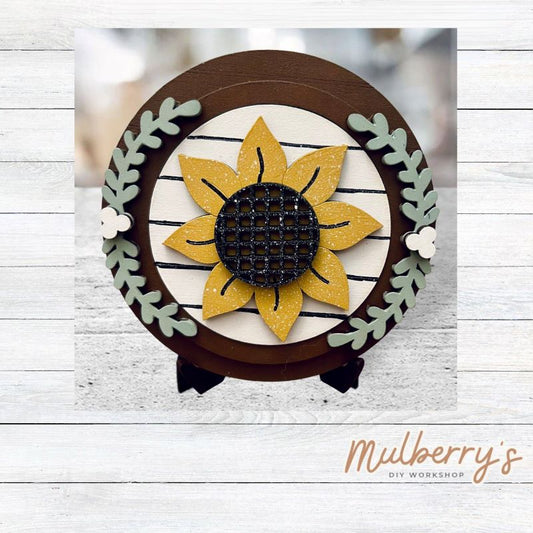 We love our mini interchangeable round stand! It's approximately 4.5 inches in diameter and can display your favorite seasonal/holiday insert.

This set includes mini interchangeable round stand with floral and sunflower insert.
