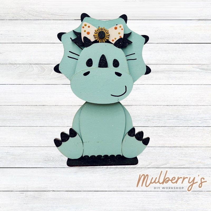 Our triceratops dinosaur is super cute! It's approximately 11.5" tall and can be paired with your favorite seasonal/holiday insert.

This set includes the interchangeable triceratops dinosaur and the sunflower headbow insert. Please note that we currently offer only one sunflower insert option.

Please note that different inserts fit each type of dinosaur base differently.