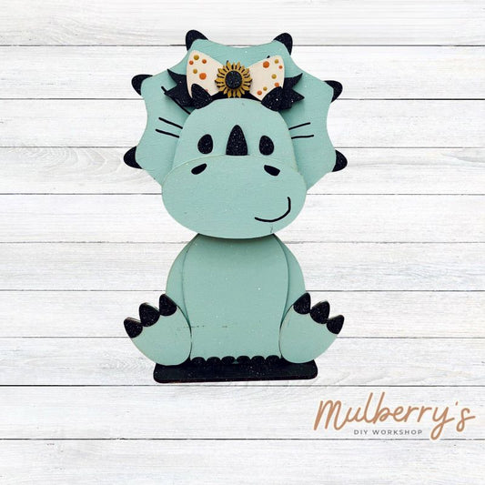 Our triceratops dinosaur is super cute! It's approximately 11.5" tall and can be paired with your favorite seasonal/holiday insert.

This set includes the interchangeable triceratops dinosaur and the sunflower headbow insert. Please note that we currently offer only one sunflower insert option.

Please note that different inserts fit each type of dinosaur base differently.