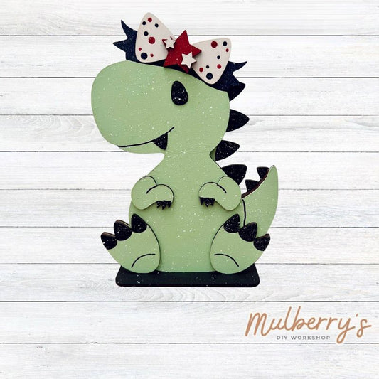 Our t-rex dinosaur is super cute! It's approximately 8" tall and can be paired with your favorite seasonal/holiday insert.

This set includes the interchangeable t-rex dinosaur and your choice of July 4th inserts:

-Headband with Bow Tie

-Headbow

-Statue of Liberty Spike Hat

Please note that different inserts fit each type of dinosaur base differently. For our interchangeable t-rex, we recommended pairing it with the headbow insert.