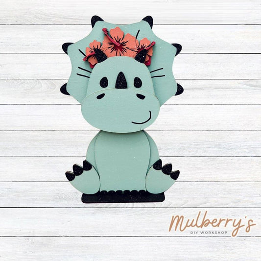 Our triceratops dinosaur is super cute! It's approximately 11.5" tall and can be paired with your favorite seasonal/holiday insert.

This set includes the interchangeable triceratops dinosaur and your choice of summer inserts:

-Headband with Bow Tie

-Headbow

-Tropical Flower Lei

Please note that different inserts fit each type of dinosaur base differently. For our interchangeable triceratops, we recommended pairing it with the tropical flower lei insert.