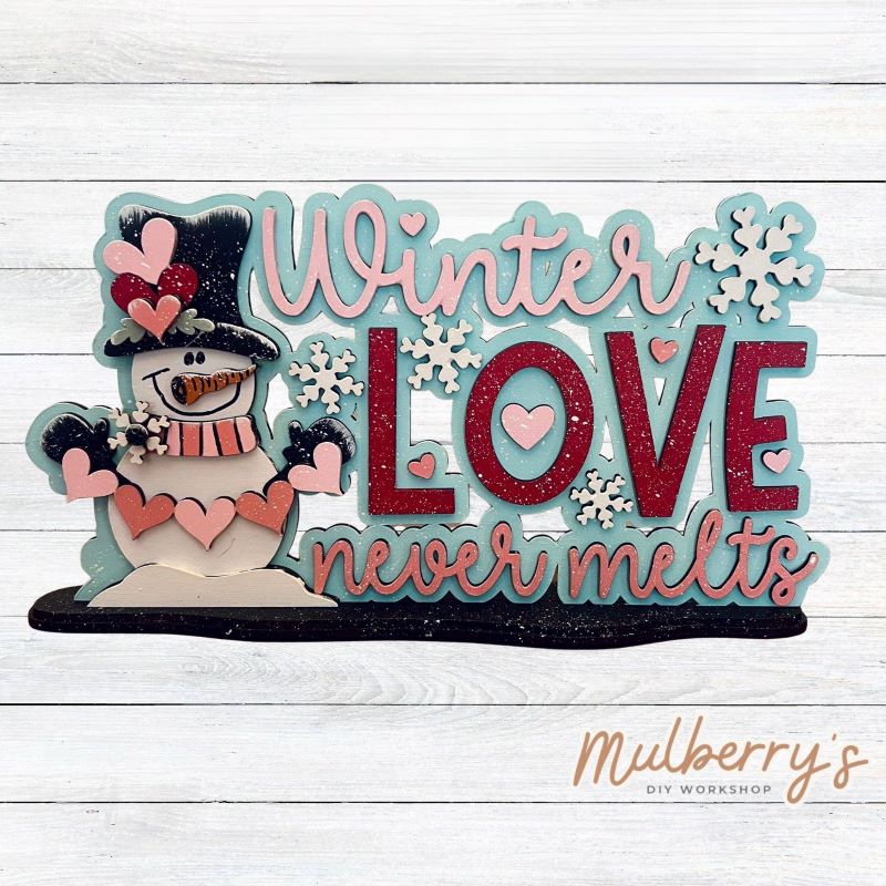 "Winter love never melts" with this adorable shelf sitter! Approximately 7" wide by 9" tall. Includes a stand.